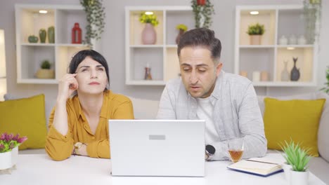 The-couple-is-looking-at-the-laptop-and-is-thoughtful.